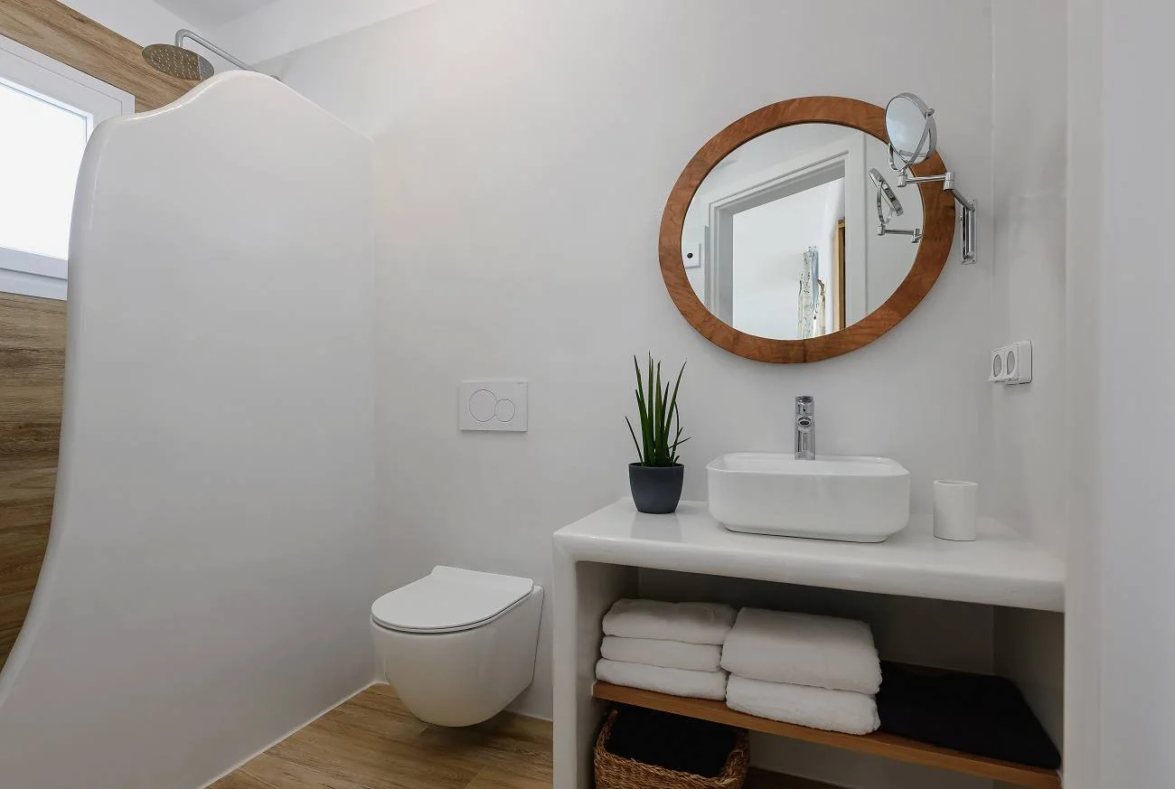 Bathroom with a round mirror and walk-in shower